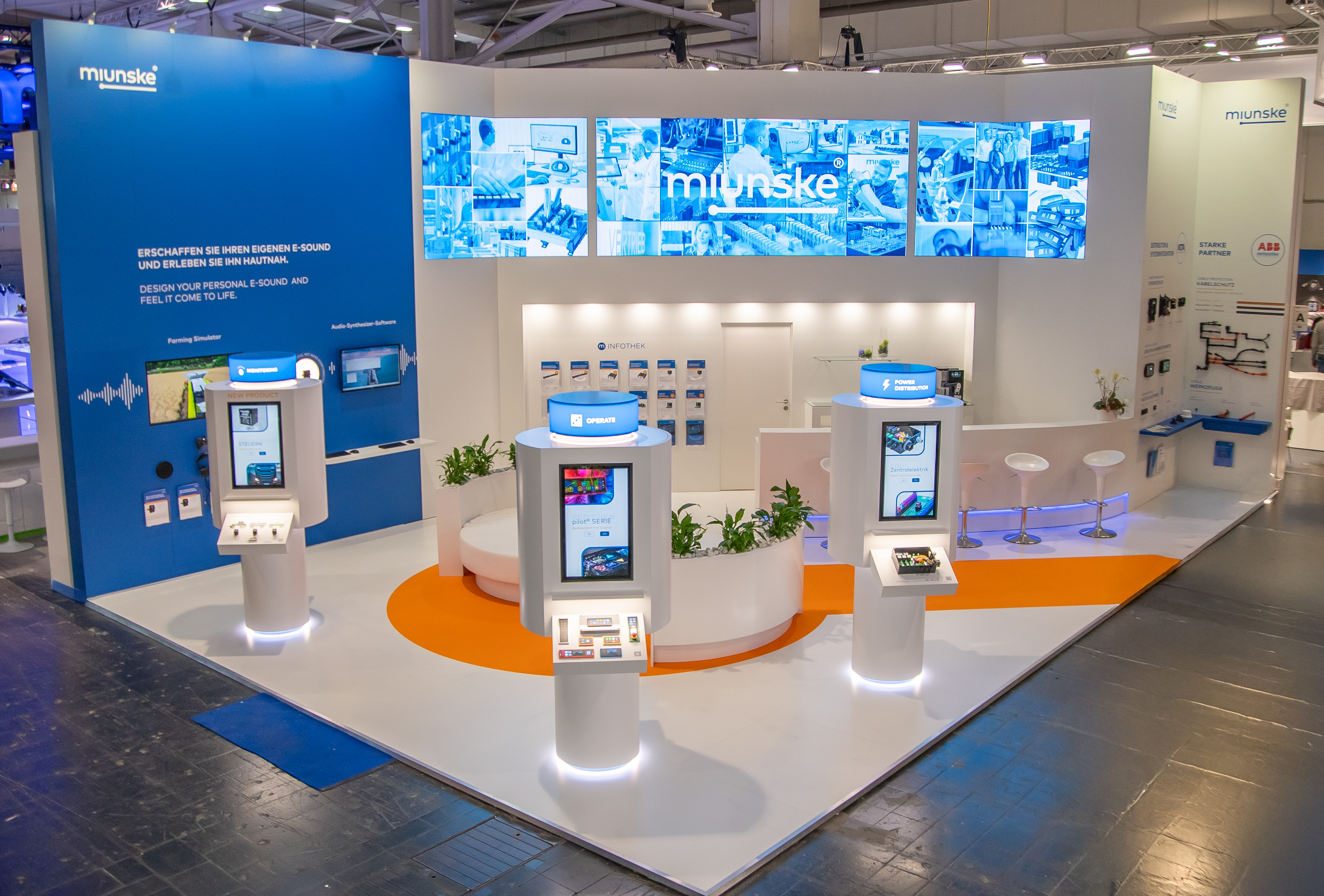 Digital touchscreen kiosk with illuminated blue base, displayed at a trade show.